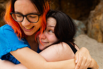 A couple of girls hug each other with affection and joy during a day at the beach