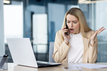 Frustrated businesswoman arguing on the phone at her desk