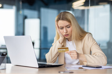 Worried woman discovering credit card fraud at workplace