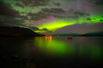 Northern light dancing over calm lake in north of Sweden. Abisko national park. - 774155089