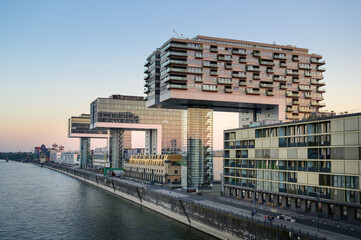 Promenade at the Rhine Harbor in Cologne, Germany: Modern apartment and office buildings line the...