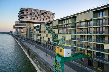 Promenade at the Rhine Harbor in Cologne, Germany: Modern apartment and office buildings line the formal industrial harbor - 774159253