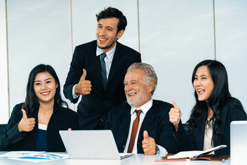 Senior caucasian manager working in office with assistance of young Asian business people and...