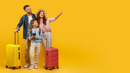 Family prepared for vacation travel on yellow background