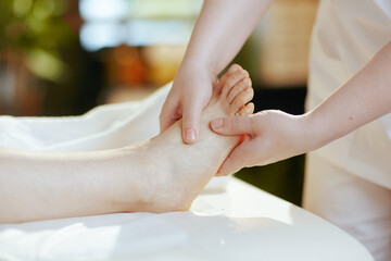 Closeup on medical massage therapist massaging clients foot - 774166815