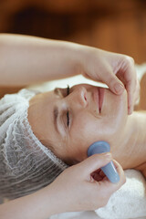 massage therapist in spa salon massaging clients face - 774166843