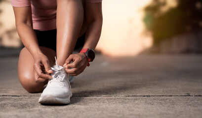 Woman runner tying shoelaces,Jogging concept at outdoors