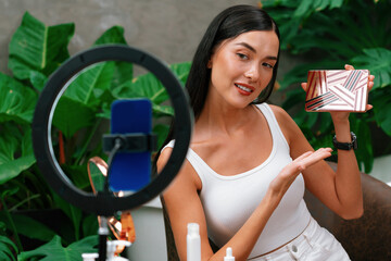 Young woman making natural beauty and cosmetic tutorial on green plant garden video content for...