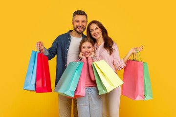 Family showing shopping bags and smiling widely