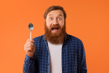 Emotional man with red hair and beard holding spoon, studio