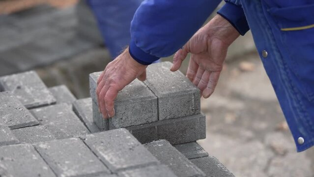 Laying interlocking pavers during the construction of sidewalks and roads
