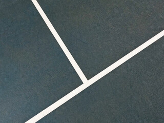 Racquet or Paddle Sports Court Surface Close-Up. Vibrant colored sport or tennis court surface. Close-up views of the white boundary lines against a blue surface. Diagonal point of view.