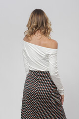 Serie of studio photos of female model wearing viscose fitted white shirt and patterned midi skirt...