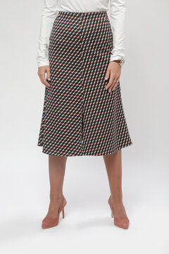 Serie of studio photos of female model wearing viscose fitted white shirt and patterned midi skirt with slit