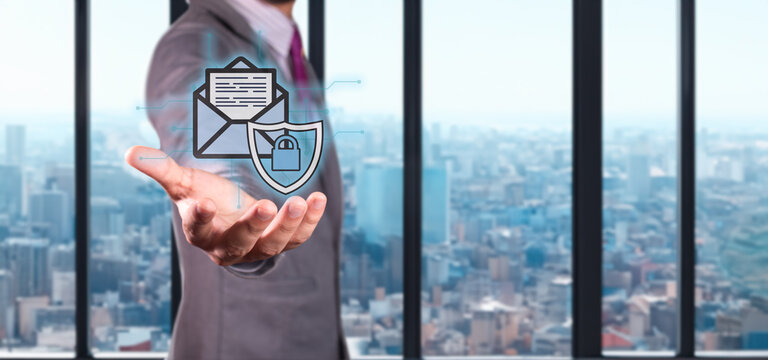 cybersecurity and data protection concept. executive holds hologram of envelope with shield and padlock.