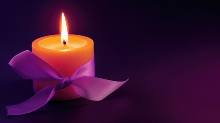 A lit orange candle with a purple ribbon on dark background