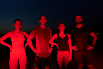 Diverse Athletes Unwind: Post-Marathon Rest Under Red Nighttime Glow.