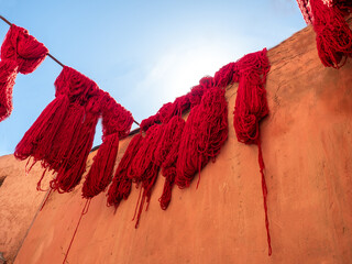 Colorful threads hanging on a wall in Morocco