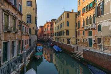 Fototapeta na wymiar Typical narrow canal surrounded by buildings with boat in Venice, Veneto, Italy