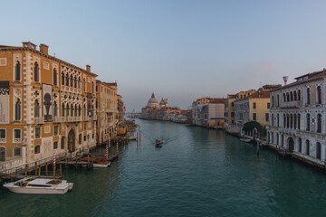 Fototapeta na wymiar View of Grand Canal and Basilica Santa Maria della Salute seen from the Rialto Bridge on a hazy winter evening, Venice, Veneto, Italy
