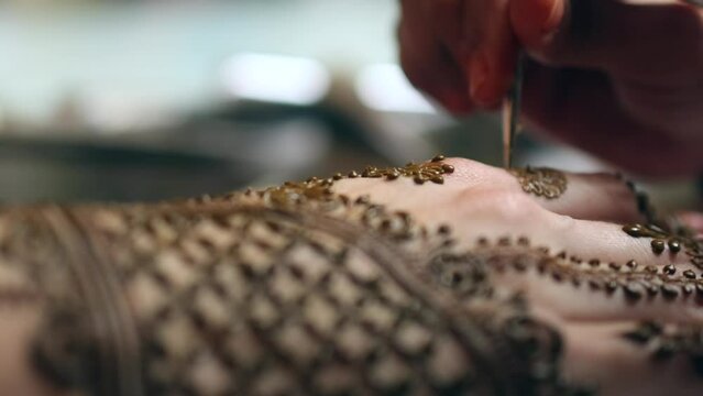 aplicando un tatuaje hindu en las manos de una mujer