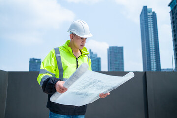 Construction Engineer Evaluating Blueprints on Rooftop