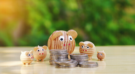 5 wooden piggy bank and money coins stack on a wooden table with a natural background, Financial...