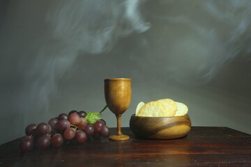 Holy communion on wooden table on church.Taking holy Communion.Cup of wood with red wine, bread.The...