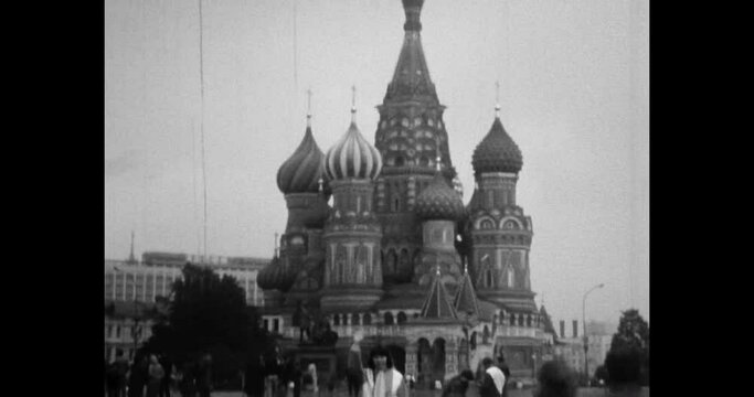 Gingerbread House on Red Square. St. Basil's Cathedral in 1980s Moscow city, Russia. People walk, visit famous travel architecture destination. Archival vintage black white film. Old retro archive