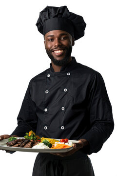 A happy male chef in a modern black uniform with a plate of grilled vegetables and beef, suggesting fine cookery