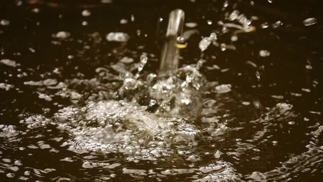 Water drips into large puddle. Slow movement.