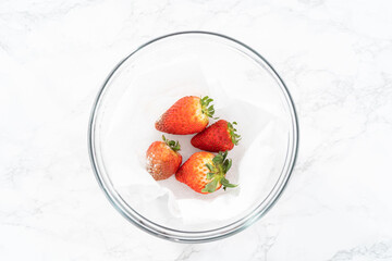 Fresh and Moldy Strawberries in a Glass Bowl on a White Napkin