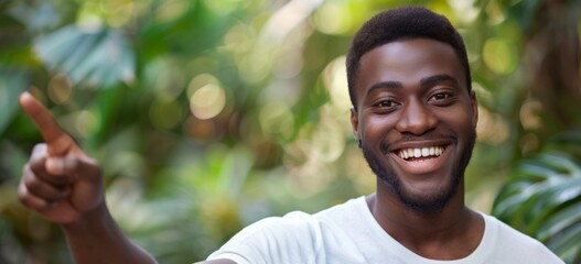 African american male person with toothy smile on face pointing with index finger on empty space over green background. - obrazy, fototapety, plakaty