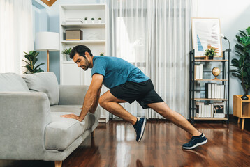 Athletic body and active sporty man using furniture for effective targeting muscle gain exercise at...