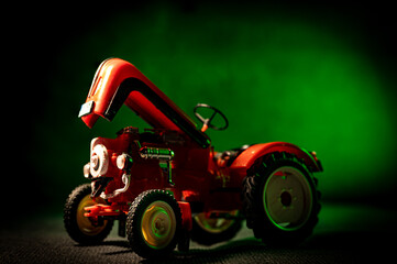 Czerwony traktor na zielonym tle. - obrazy, fototapety, plakaty