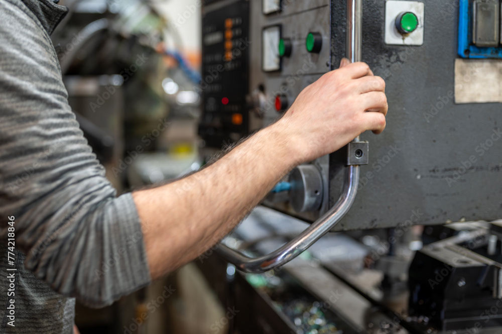 Wall mural worker pressing buttons on cnc machine control board in factory. high quality photography.