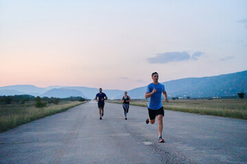 A diverse group of runners trains together at sunset.