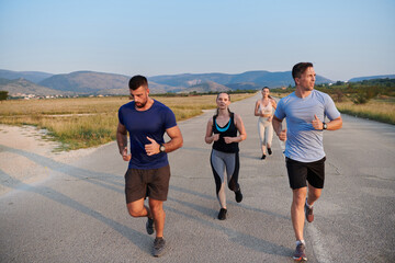 A group of friends maintains a healthy lifestyle by running outdoors on a sunny day, bonding over fitness and enjoying the energizing effects of exercise and nature - 774229027