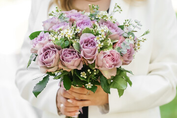 A bride holds rustic wedding bouquet consisting of different flowers. Decoration Artwork. Soft....
