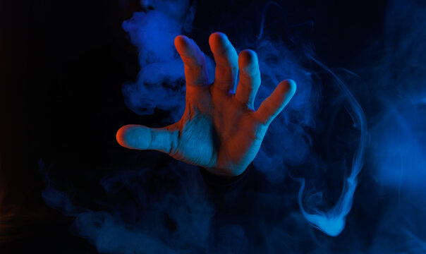 Mystical smoke in scary hands. Mysterious composition. Fortune teller, mind power, prediction, halloween concept. Wide angle horizontal wallpaper or web banner. Mockup for your logo.
