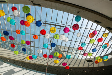 Installation of colorful umbrellas under the roof of the shopping center