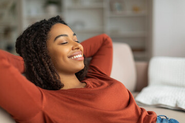 Relaxed Black Woman Enjoying Comfortable Moment on a Sofa at Home