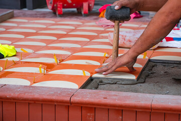 industrial ceramic  builder worker installing floor tile at repair renovation work - Handyman installing ceramic tiles - A special cement mass to fill gaps between the laid ceramics.