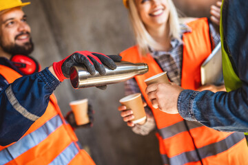  Three constructions workers having a coffee break at construction site