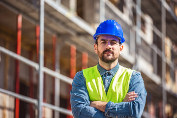 Construction site manager standing  wearing safety vest and helmet, thinking at construction site....