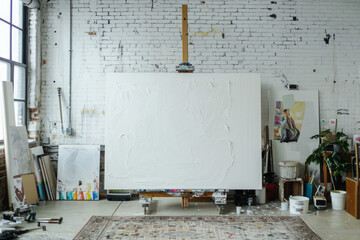 Art studio with textured white painting and supplies