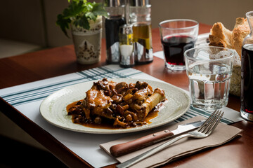 Hearty Breakfast: Braised Pork's Trotters with Mushrooms - Traditional Catalan Cuisine in a Rustic Restaurant Ambiance.