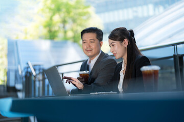 Business professionals working outdoors with laptop