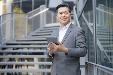 Confident businessman with tablet outdoors