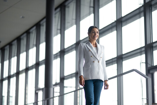Good-looking woman in white jacket and jeans in the office building